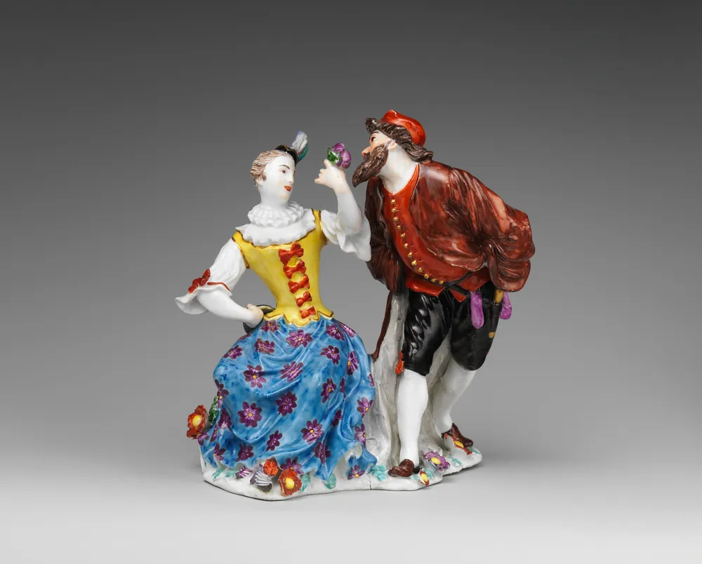 A Meissen porcelain group of Columbine and Pantalone, brightly enamelled, on a flower-strewn base