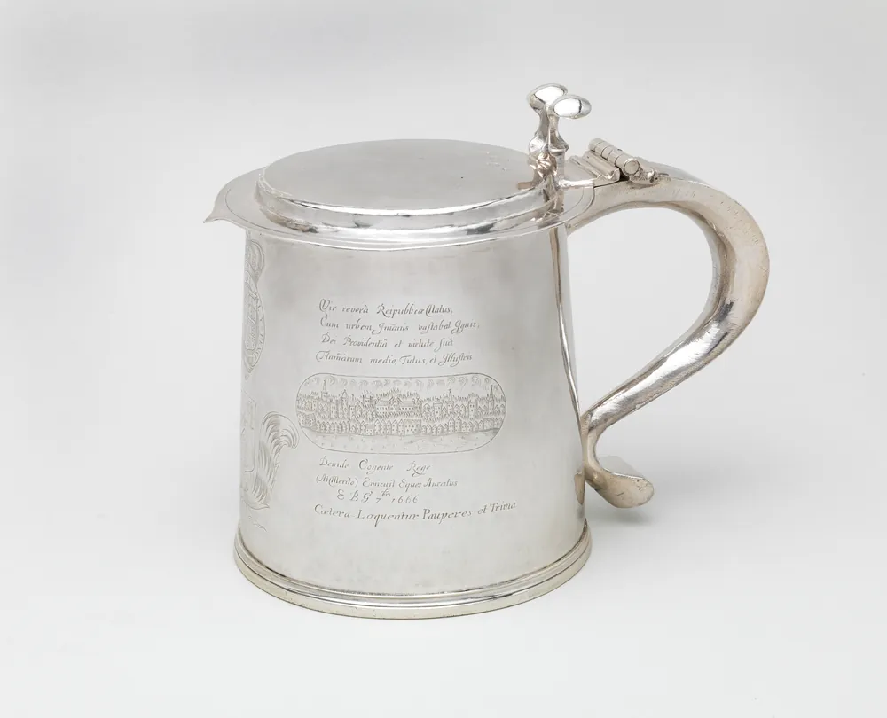 A plain silver tankard engraved with a Latin inscription and a view of the London skyline