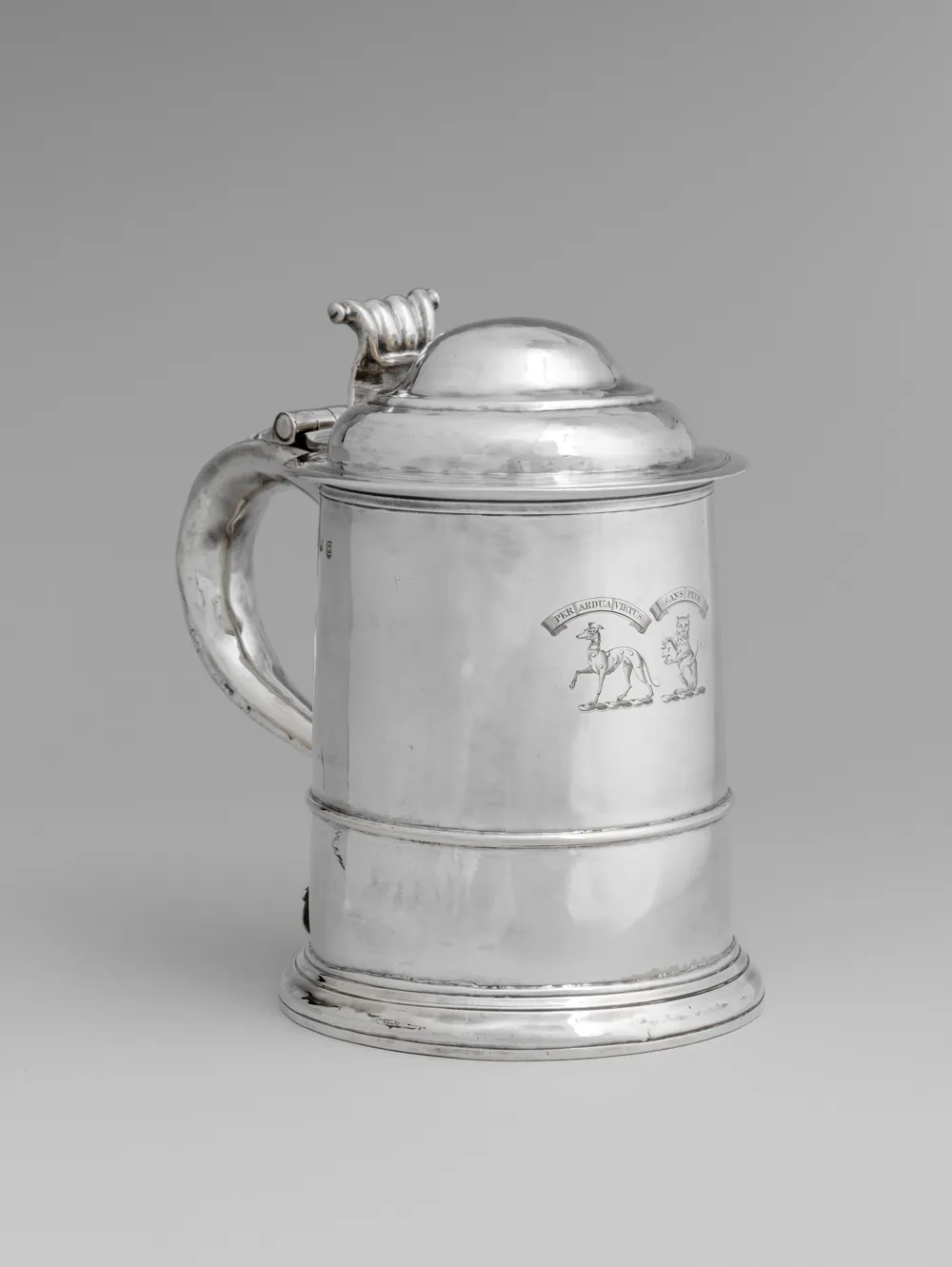 A plain English silver tankard with a domed lid, engraved with a crest, the small hallmarks struck on the body beside the handle